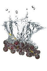 Image showing blue grape dropped into water with splash isolated on white
