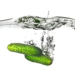 Image showing two green cucumbers dropped into water isolated on white