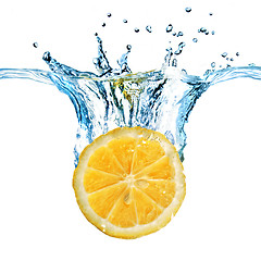 Image showing Fresh lemon dropped into water with splash isolated on white