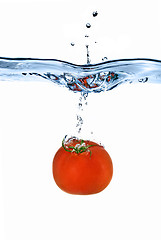 Image showing red tomato dropped into water isolated on white