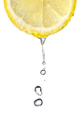 Image showing Fresh lemon slice with water drops isolated on white