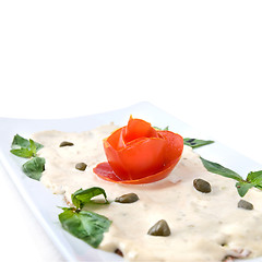 Image showing slices of ham with sauce on the plate isolated on white