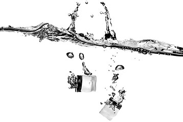 Image showing ice cubes dropped into water with splash isolated on white