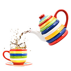 Image showing color teapot with cup and splash of tea isolated on white