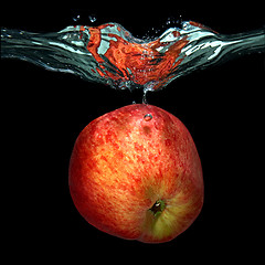 Image showing green apple dropped into water with splash isolated on black