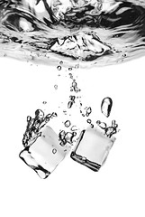 Image showing ice cubes dropped into water with splash isolated on white