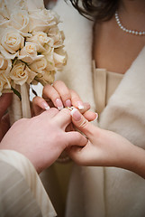 Image showing puttting on a wedding ring. natural photo