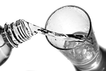 Image showing water pouring into glass from bottle isolated on white