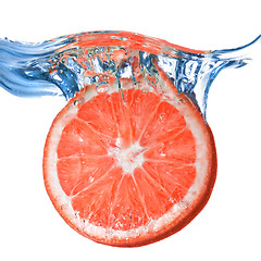 Image showing Fresh grapefruit dropped into water with bubbles isolated on whi