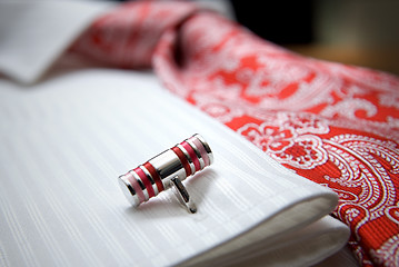 Image showing close-up photo of stud on white shirt with red tie