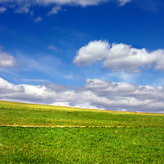 Image showing Green field against blue sky and clouds
