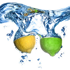 Image showing lemon and lime dropped into water with bubbles isolated on white