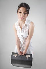 Image showing begging brunette with travel bag in white dress