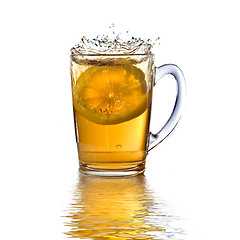 Image showing lemon dropped into tea cup with splash and reflection isolated o