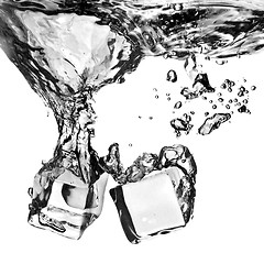 Image showing ice cubes dropped into water with splash isolated on white