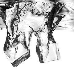 Image showing ice cubes dropped into water with splash isolated on white