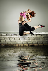 Image showing girl jumping on the roof in the water