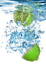 Image showing Fresh lime dropped into water with bubbles isolated on white