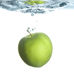 Image showing green apple dropped into water with bubbles isolated on white