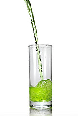 Image showing green juice pouring into glass isolated on white