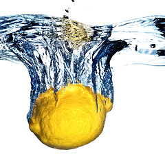 Image showing Fresh lemon dropped into water with bubbles isolated on white