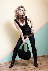 Image showing attractive woman posing against the wall with bag