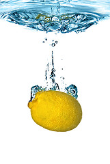 Image showing Fresh lemon dropped into water with bubbles isolated on white