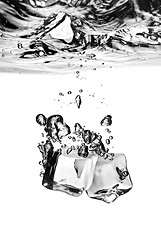 Image showing ice cubes dropped into water with splash isolated on white