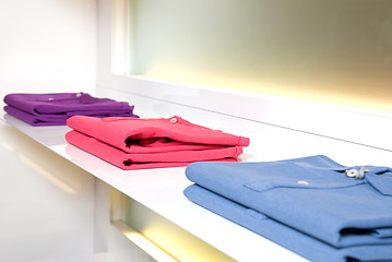 Image showing white store shelf with color clothes