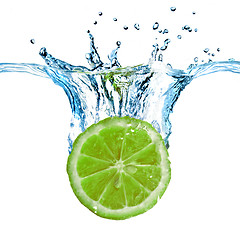 Image showing Fresh lime dropped into water with splash isolated on white