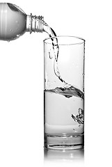 Image showing water pouring into glass from bottle isolated on white