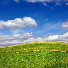 Image showing Green field against blue sky and clouds