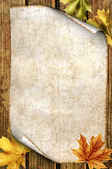 Image showing old paper with autumn leaves on wood