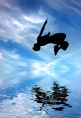 Image showing silhouette of jumping man against blue sky and clouds