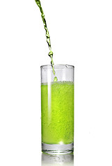 Image showing green juice pouring into glass isolated on white