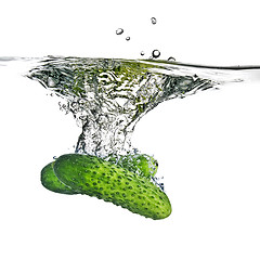 Image showing green cucumbers dropped into water isolated on white