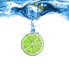 Image showing Fresh lime dropped into water with bubbles isolated on white