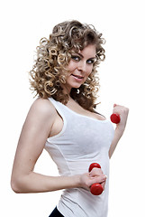 Image showing Portrait of young sexy woman holding dumbbells isolated on white