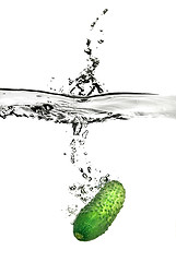 Image showing green cucumber dropped into water isolated on white