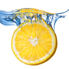 Image showing Fresh lemon dropped into water with splash isolated on white