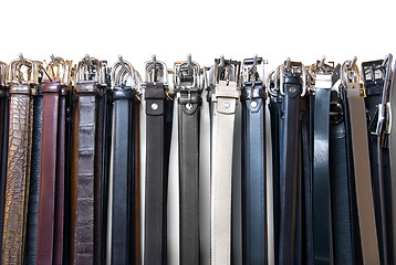 Image showing a lot of leather belts in store isolated on white