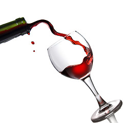 Image showing Pouring red wine in glass goblet isolated on white