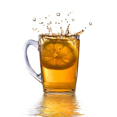 Image showing lemon dropped into tea cup with splash and reflection isolated o