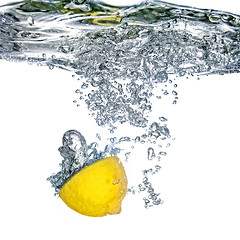 Image showing Fresh lemon dropped into water with bubbles isolated on white