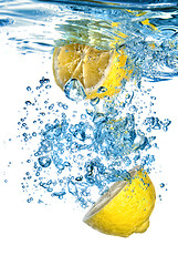 Image showing Fresh lemon dropped into water with bubbles isolated on white