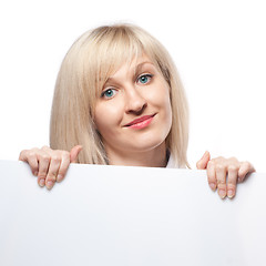 Image showing Smiling woman holding white empty paper