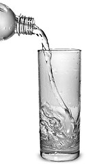 Image showing water pouring into glass from bottle isolated on white