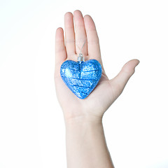 Image showing arm holding blue christmas ball in shape of heart isolated on wh