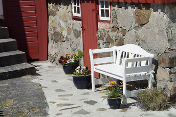 Image showing White bench and old house