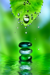 Image showing balancing spa shiny stones with leaf and water drops on green ba